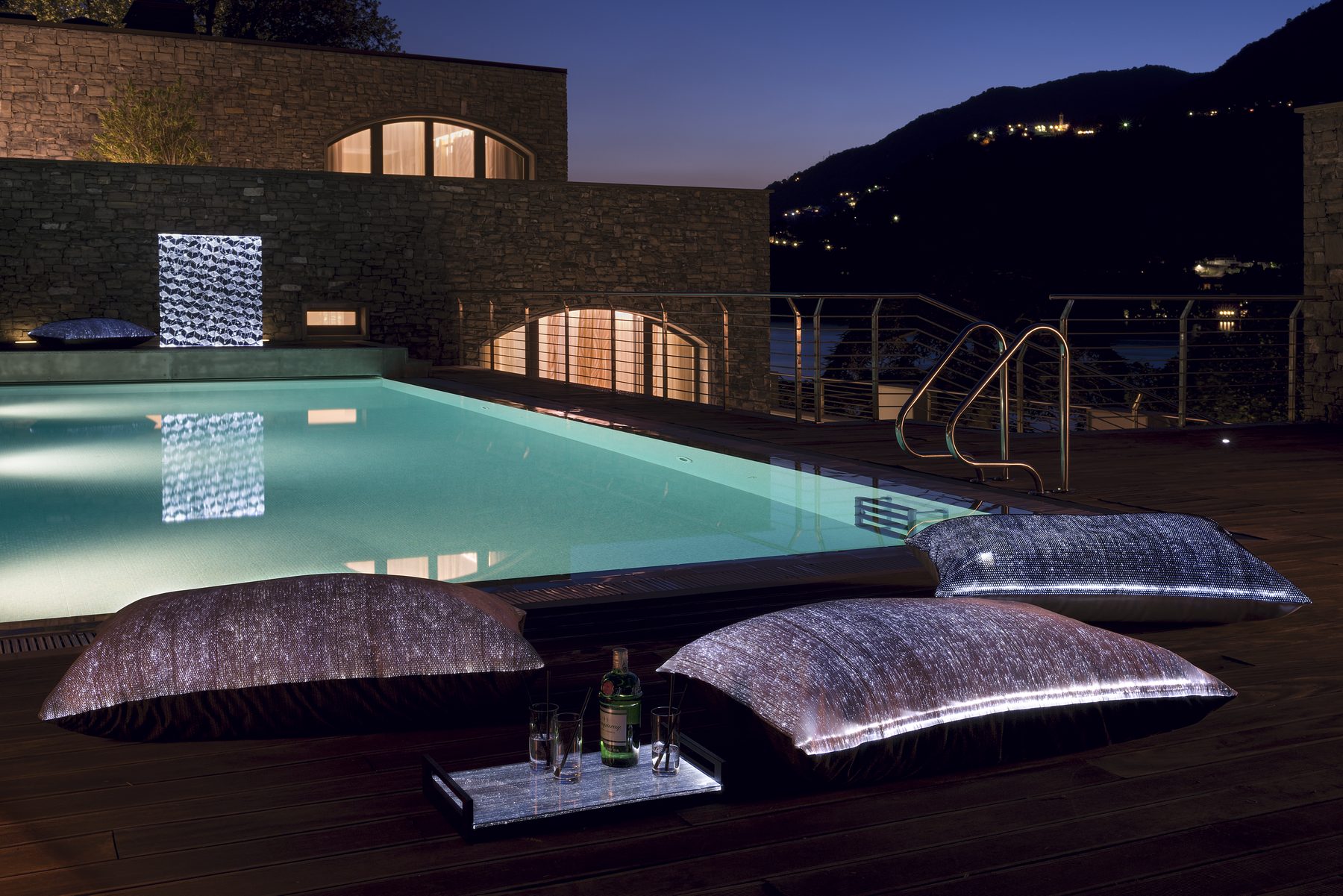 Villa pool terrace at dusk with illuminated furnishings